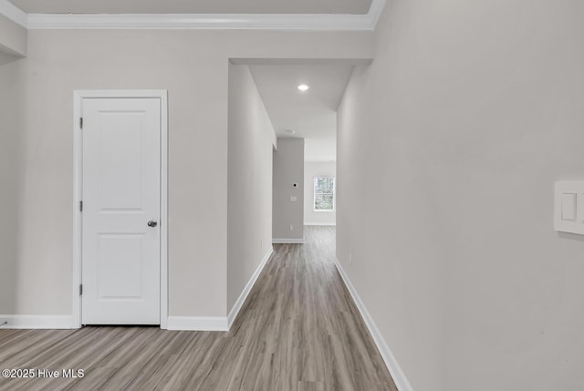 hall with crown molding and light hardwood / wood-style flooring