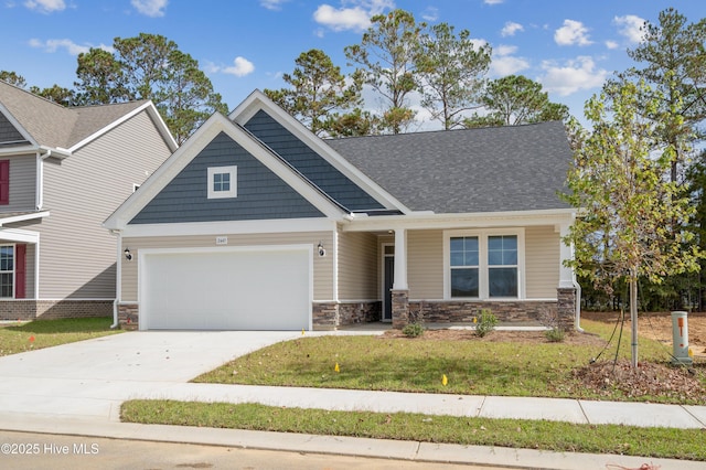 craftsman house with a garage, a shingled roof, driveway, stone siding, and a front yard