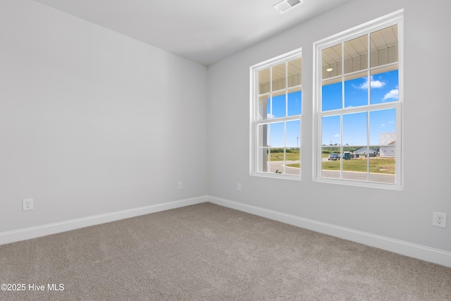 carpeted empty room with visible vents and baseboards