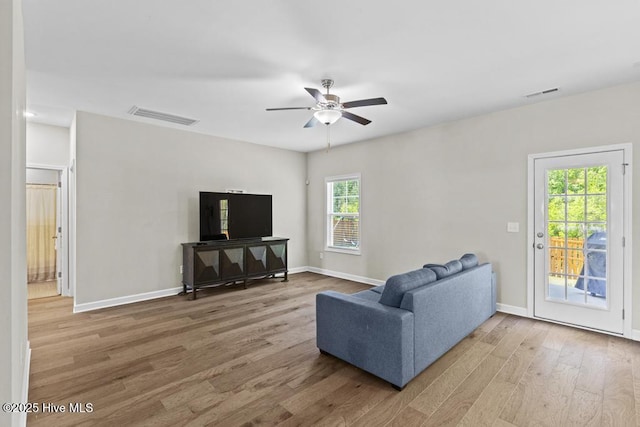 living room featuring baseboards, ceiling fan, wood finished floors, and visible vents
