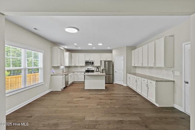 kitchen featuring a sink, appliances with stainless steel finishes, backsplash, and dark wood finished floors