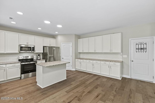 kitchen with tasteful backsplash, stainless steel appliances, visible vents, and white cabinets