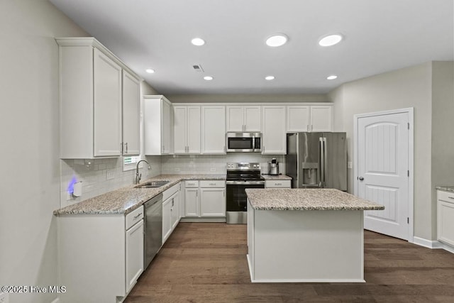 kitchen featuring a sink, white cabinetry, appliances with stainless steel finishes, and backsplash