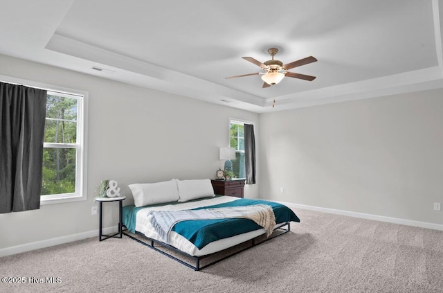 311 Mckenzie Pl, Sneads Ferry, NC 28460 - bedroom featuring a raised ceiling, light colored carpet, baseboards, and a ceiling fan