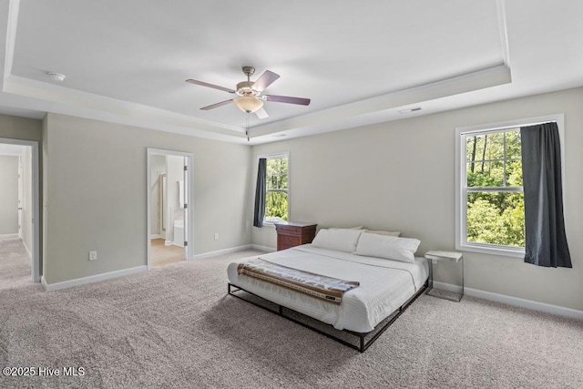 bedroom featuring carpet floors, baseboards, and a tray ceiling