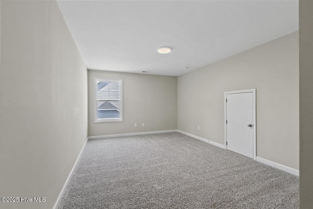 empty room featuring carpet floors and baseboards
