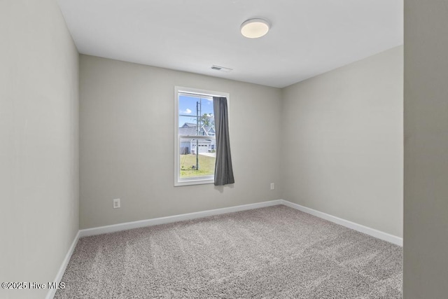 carpeted spare room with baseboards and visible vents