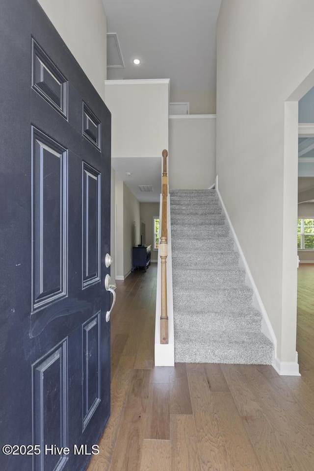 foyer entrance with baseboards, recessed lighting, stairs, and wood finished floors
