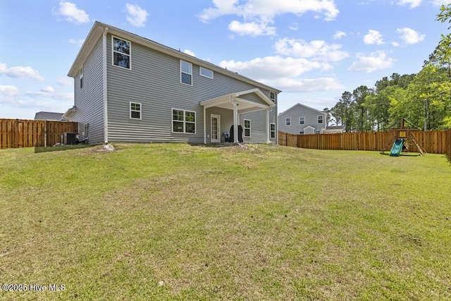 rear view of house with a fenced backyard, a playground, a yard, and cooling unit