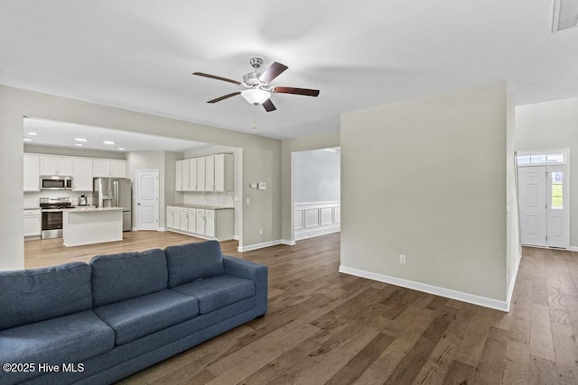 living area with ceiling fan, recessed lighting, baseboards, wood finished floors, and visible vents