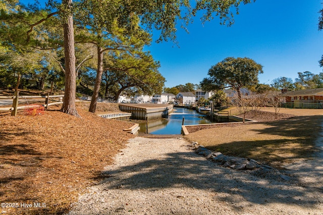 view of pool with a boat dock and a water view