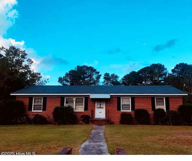 ranch-style home with a front lawn and brick siding