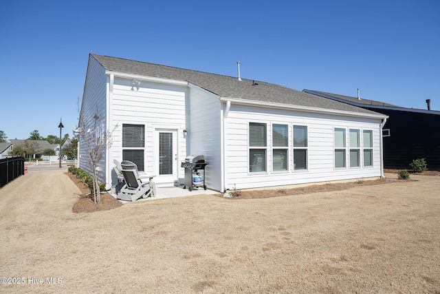 rear view of house featuring a patio and a yard