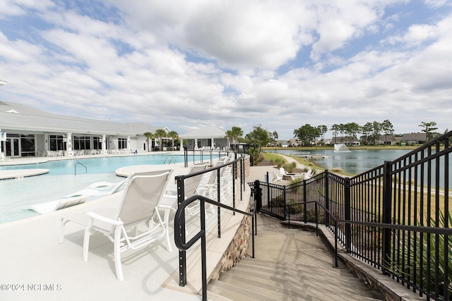 view of pool with a water view and a patio area