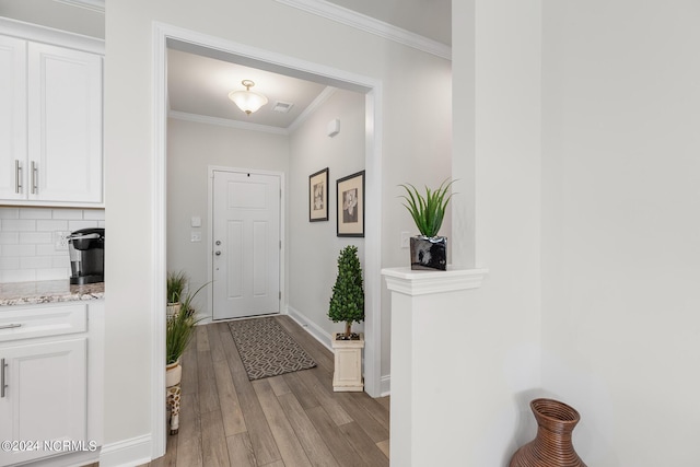 entryway with crown molding and light hardwood / wood-style flooring