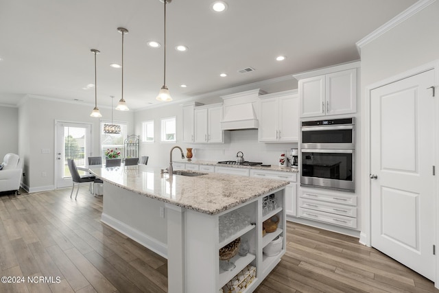 kitchen with hanging light fixtures, white cabinetry, sink, and stainless steel double oven