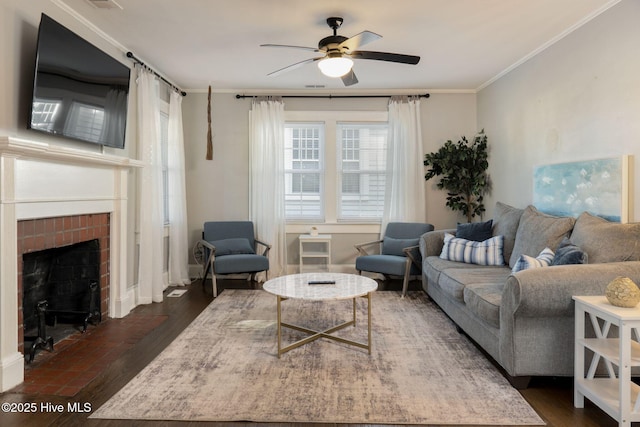 living room featuring a fireplace, crown molding, dark wood-type flooring, and ceiling fan