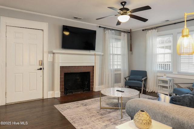 living room featuring crown molding, ceiling fan, a fireplace, and dark hardwood / wood-style flooring