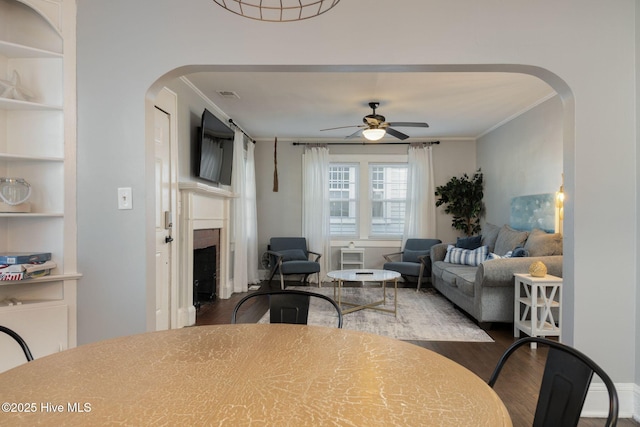 dining space featuring wood-type flooring, ceiling fan, and crown molding