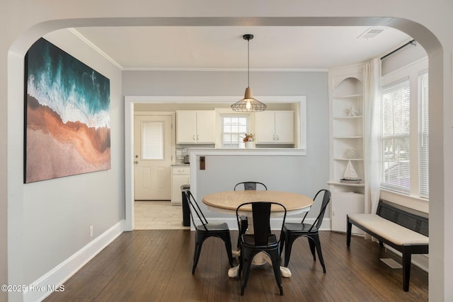 dining room featuring hardwood / wood-style flooring, plenty of natural light, and ornamental molding