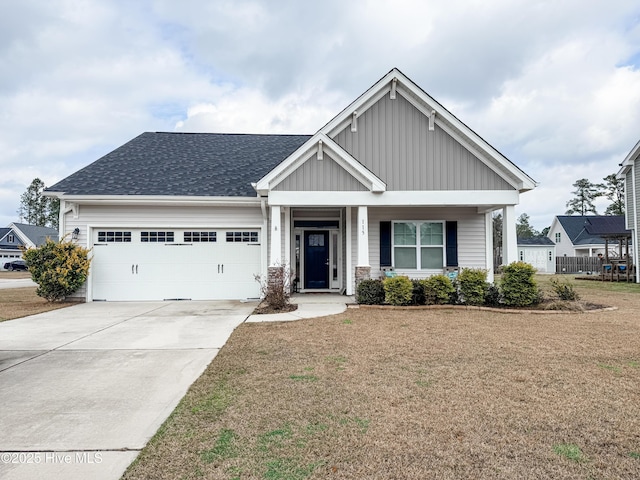 craftsman-style home featuring a garage, a front yard, and covered porch