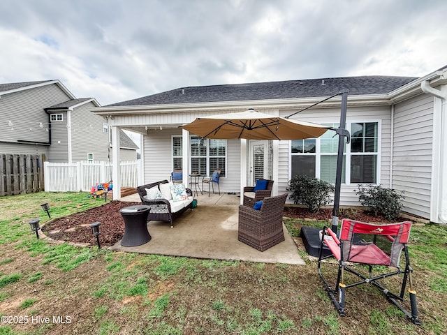 rear view of property featuring an outdoor living space, a yard, and a patio