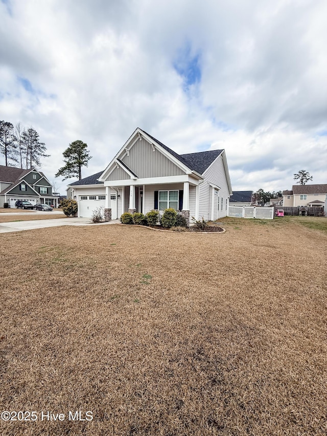 craftsman-style house featuring a garage, covered porch, and a front lawn