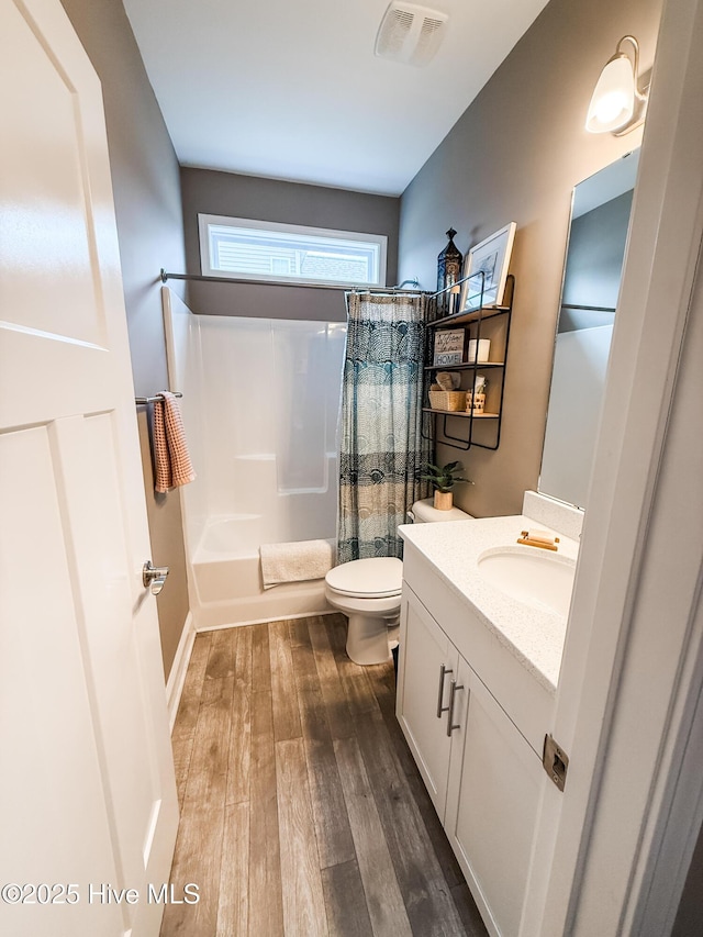 full bathroom with shower / tub combo, vanity, hardwood / wood-style flooring, and toilet