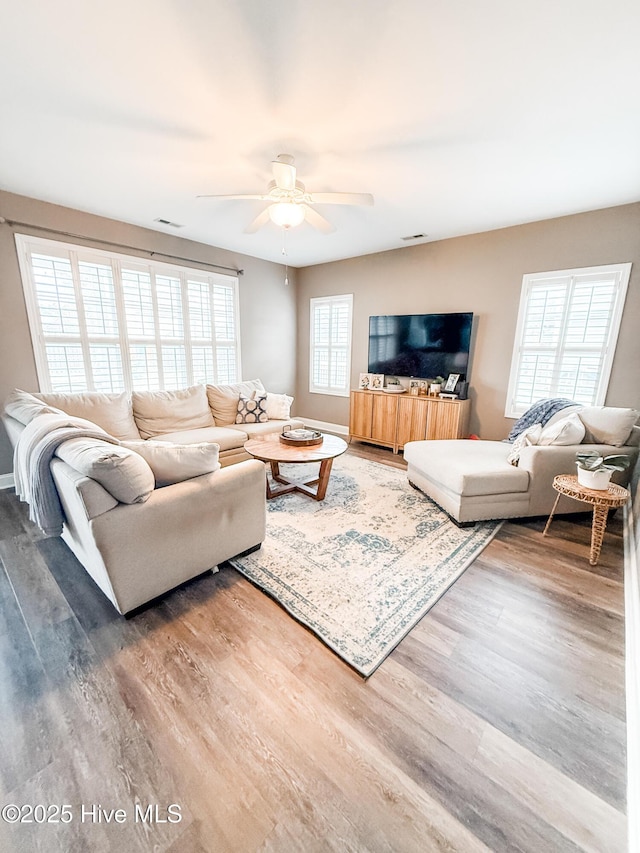 living room featuring wood-type flooring and ceiling fan