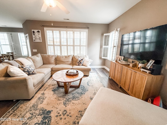 living room featuring ceiling fan, dark hardwood / wood-style floors, and a healthy amount of sunlight