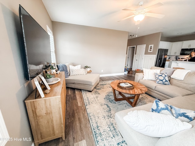 living room with dark wood-type flooring and ceiling fan