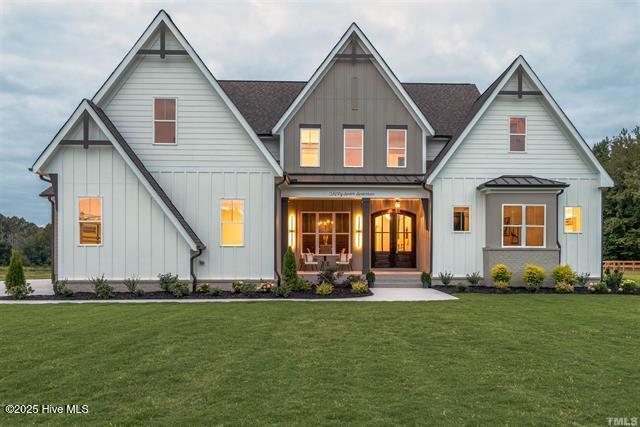 back of property with a yard and covered porch