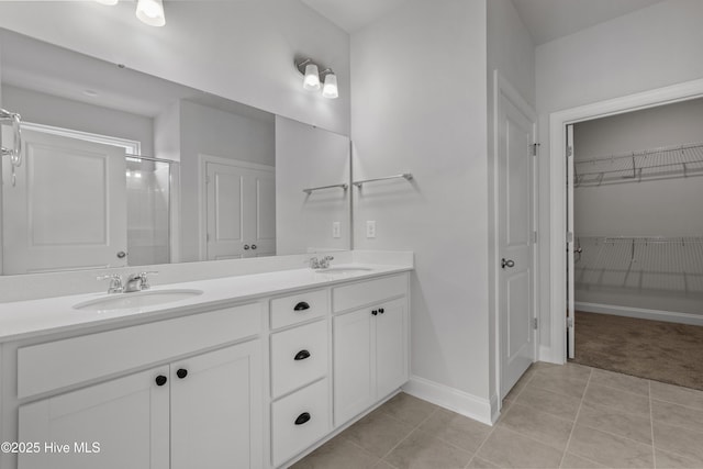 1204 Calabash Station Blvd NW, Calabash, NC 28467 - bathroom with double vanity, a stall shower, baseboards, a walk in closet, and tile patterned floors