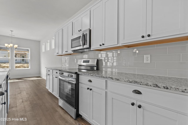 1204 Calabash Station Blvd NW, Calabash, NC 28467 - kitchen with appliances with stainless steel finishes, backsplash, baseboards, white cabinetry, and a chandelier