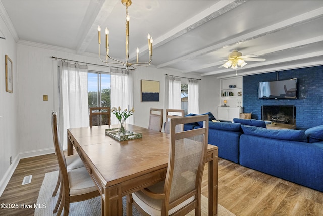 3401 Taylor St, Morehead City, NC 28557 - dining room featuring a brick fireplace, light hardwood / wood-style flooring, built in features, beamed ceiling, and ceiling fan