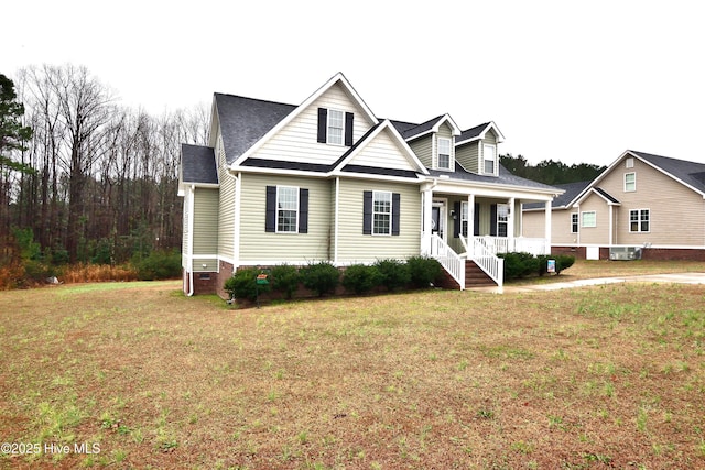 view of front of home with cooling unit, a front lawn, and a porch