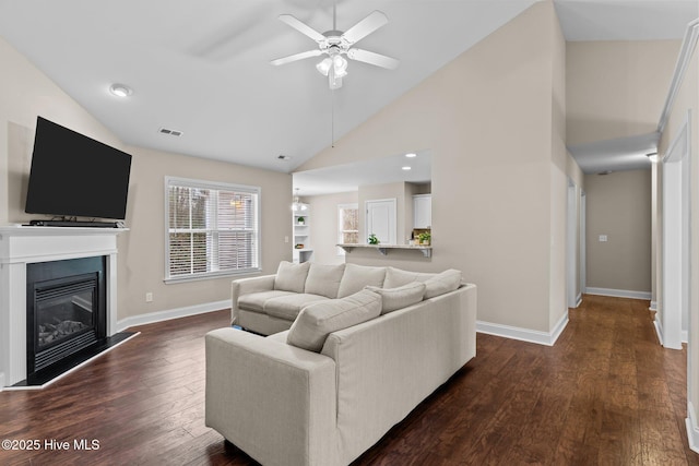 living room with ceiling fan, dark hardwood / wood-style flooring, and high vaulted ceiling