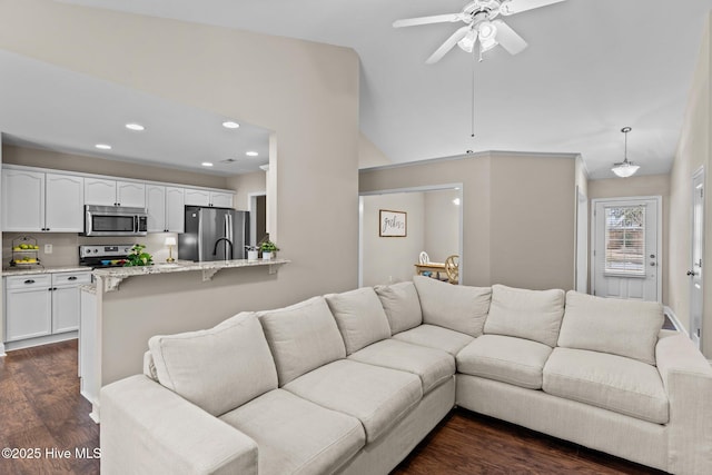 living room featuring dark wood-type flooring, ceiling fan, and lofted ceiling