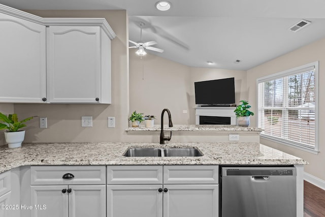 kitchen with white cabinetry, dishwasher, light stone countertops, and sink