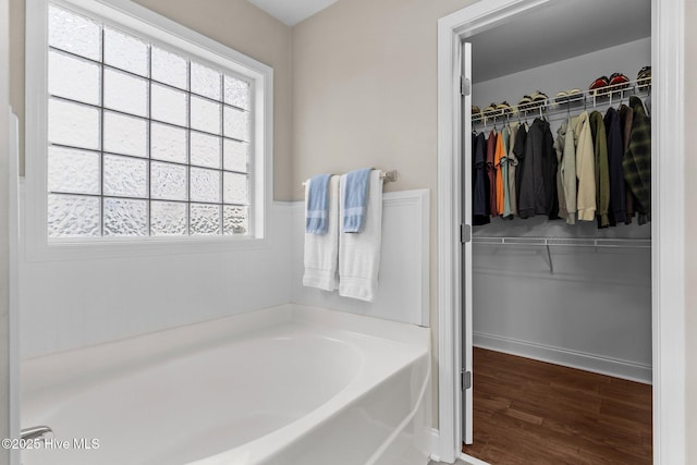 bathroom featuring hardwood / wood-style floors, a wealth of natural light, and a bathing tub