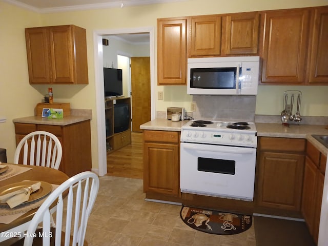 kitchen with crown molding and white appliances