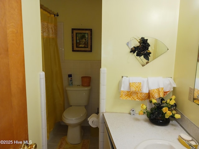 bathroom with vanity, tile walls, tile patterned floors, and toilet