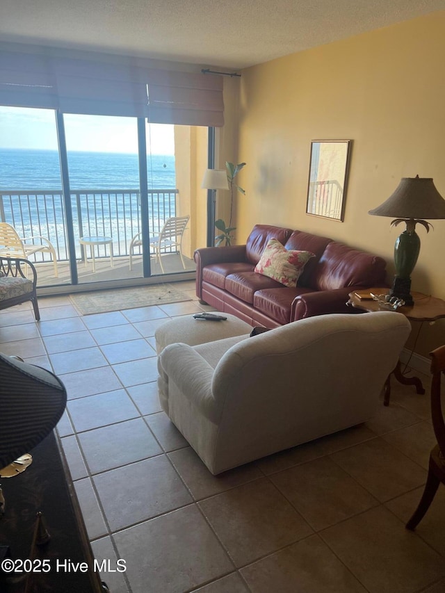 tiled living room with a textured ceiling and a water view