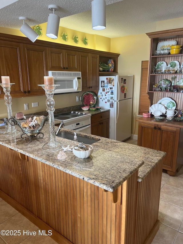 kitchen featuring white appliances, light tile patterned floors, a peninsula, light stone countertops, and open shelves