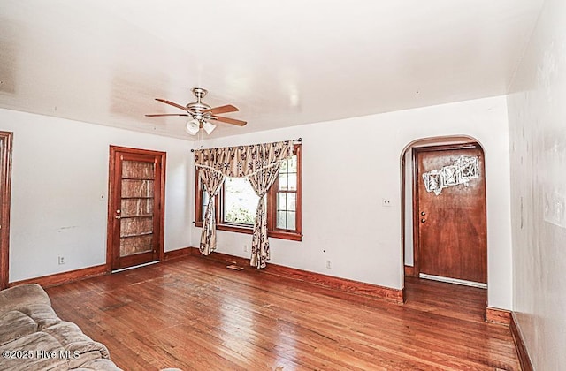 unfurnished living room featuring ceiling fan and dark hardwood / wood-style flooring