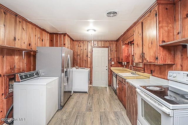 kitchen with white range with electric cooktop, washer / clothes dryer, sink, and light hardwood / wood-style flooring