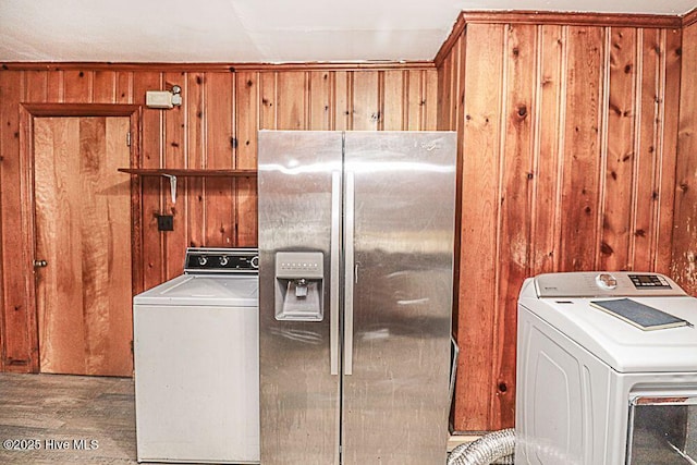 washroom with washer / clothes dryer, wooden walls, and light hardwood / wood-style floors