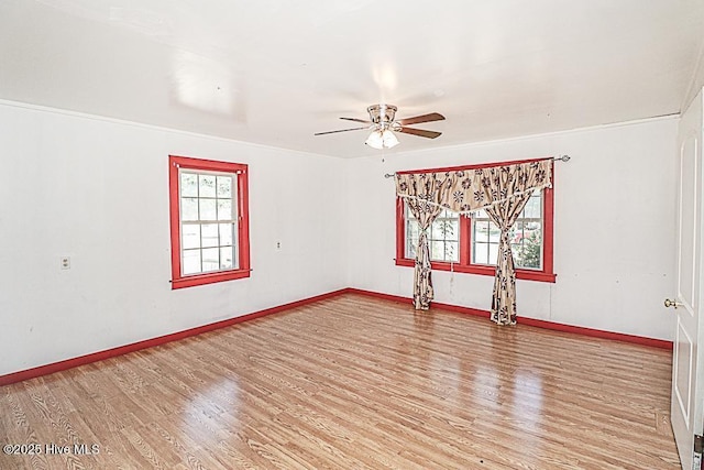 empty room with a healthy amount of sunlight, hardwood / wood-style floors, and ceiling fan