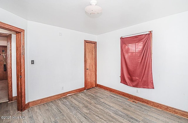 unfurnished room with wood-type flooring