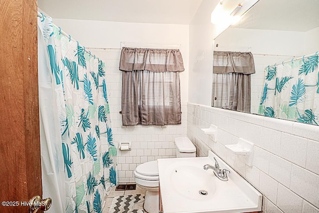 bathroom featuring sink, tile walls, tile patterned flooring, walk in shower, and toilet